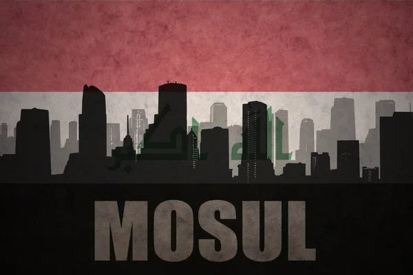 Silhueta abstrata da cidade com texto Mosul no fundo da bandeira iraqi vintage — Fotografia de Stock
