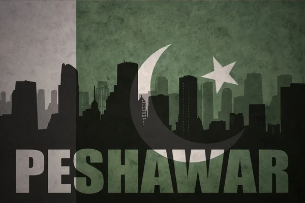 Silhueta abstrata da cidade com texto Peshawar no fundo da bandeira do paquistão vintage — Fotografia de Stock