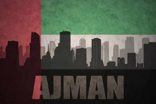 Silueta abstracta de la ciudad con texto Ajman en el fondo de la bandera de los emiratos árabes unidos vintage — Foto de Stock