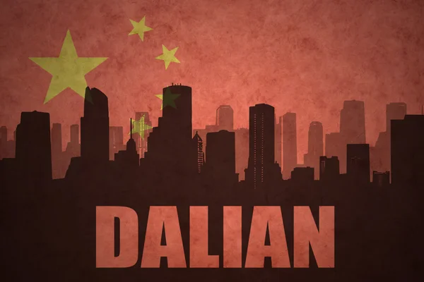 Abstraktní silueta města s textem Dalian na staré čínské vlajkové pozadí — Stock fotografie
