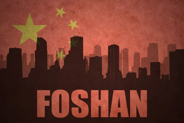 Abstraktní silueta města s textem Foshan na staré čínské vlajkové pozadí — Stock fotografie