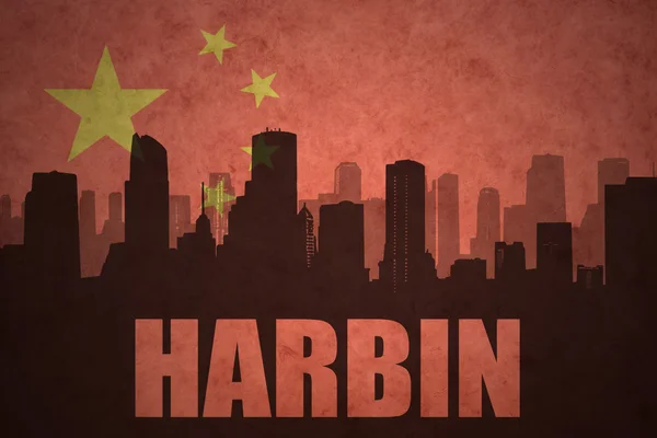 Silueta abstracta de la ciudad con texto Harbin en el fondo de la bandera china vintage — Foto de Stock