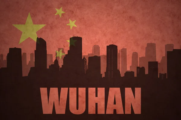 Silueta abstracta de la ciudad con texto Wuhan en el fondo de la bandera china vintage — Foto de Stock