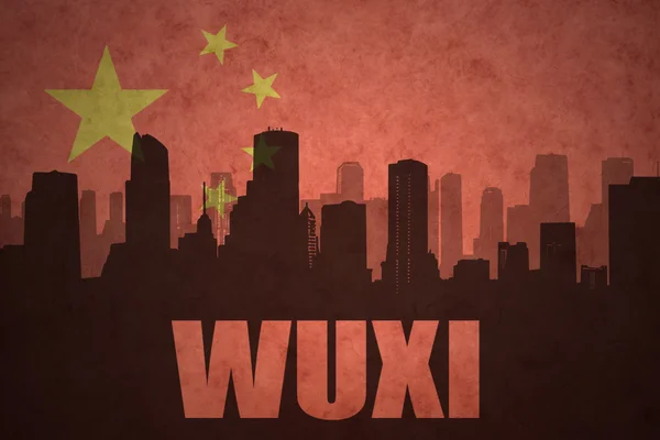 Abstraktní silueta města s textem Wuxi na staré čínské vlajkové pozadí — Stock fotografie