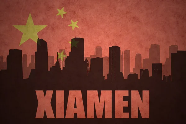 Abstraktní silueta města s textem Xiamen na staré čínské vlajkové pozadí — Stock fotografie
