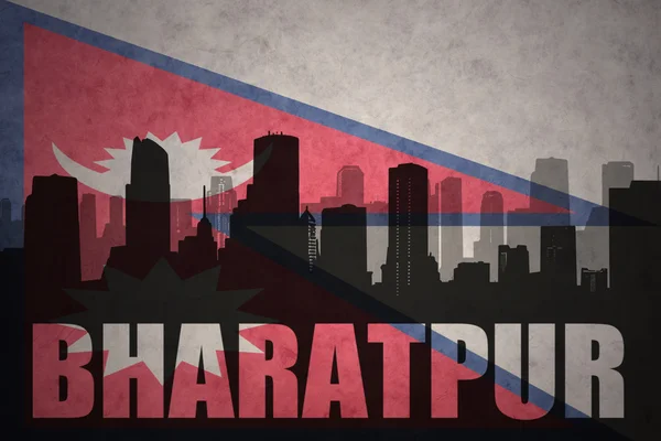 Silhouette astratta della città con testo Bharatpur sullo sfondo della bandiera nepal vintage — Foto Stock