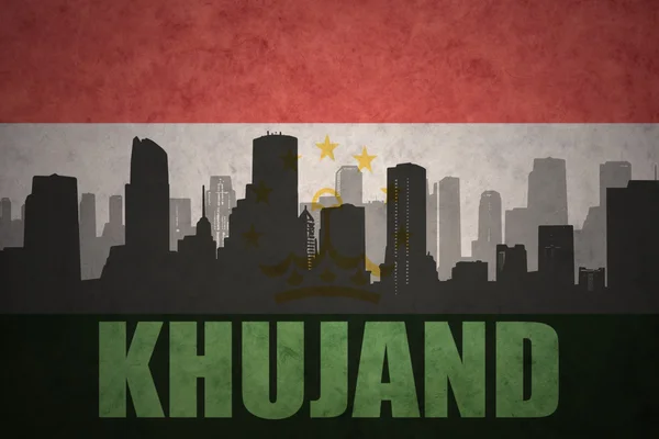 Silhueta abstrata da cidade com texto Khujand no fundo da bandeira do tajiquistão vintage — Fotografia de Stock