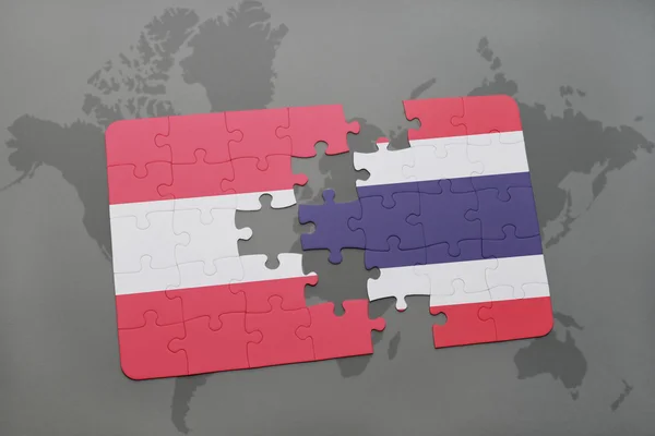 Puzzle con la bandiera nazionale di Austria e Thailandia sullo sfondo di una mappa del mondo . — Foto Stock