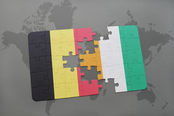 Quebra-cabeça com a bandeira nacional de belgium e cote divoire em um fundo de mapa do mundo . — Fotografia de Stock