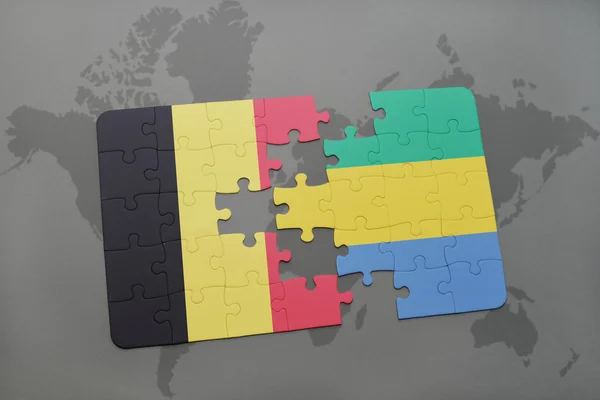 Puzzle mit der belgischen und gabunischen Nationalflagge auf einem Hintergrund der Weltkarte. — Stockfoto