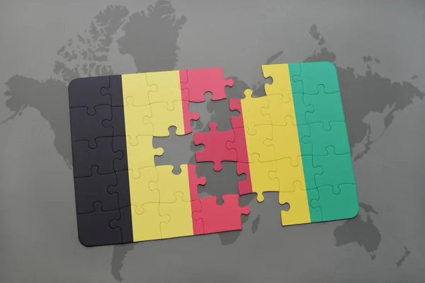 Puzzel met de nationale vlag van België en Guinee op een wereld kaart achtergrond. — Stockfoto