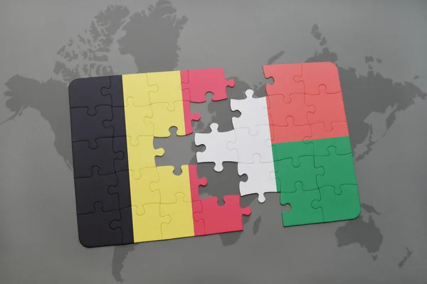 世界地图背景上与比利时和马达加斯加国旗的拼图. — 图库照片
