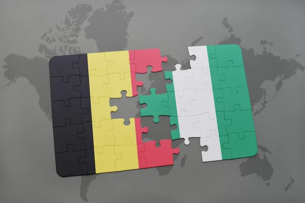 Quebra-cabeça com a bandeira nacional de bélgica e nigéria em um fundo de mapa do mundo . — Fotografia de Stock