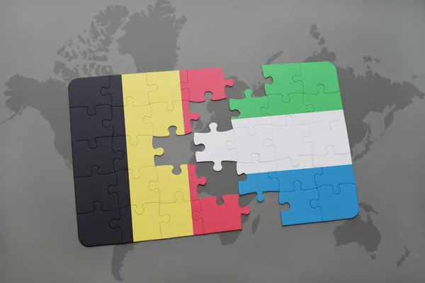 Puzzel met de nationale vlag van België en Sierra Leone op een wereld kaart achtergrond. — Stockfoto