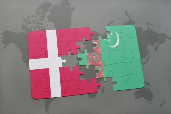 Hádanka s národní vlajkou Dánska a Turkmenistánu na pozadí mapy světa. — Stock fotografie
