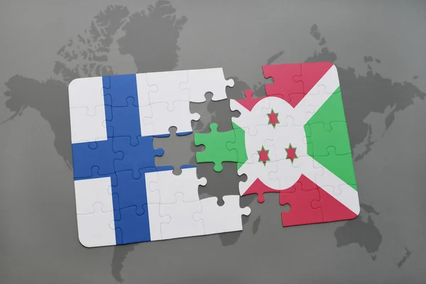 Puzzel met de nationale vlag van Finland en Burundi op een wereld kaart achtergrond. — Stockfoto