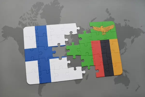 Puzzel met de nationale vlag van Finland en Zambia op een wereld kaart achtergrond. — Stockfoto