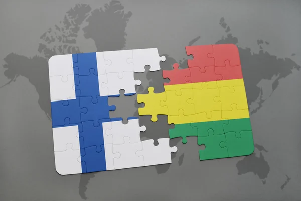 Puzzel met de nationale vlag van Finland en Bolivia op een wereld kaart achtergrond. — Stockfoto