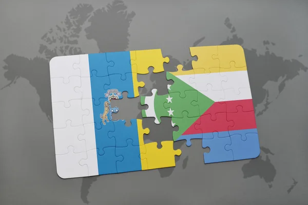Puzzle con la bandiera nazionale delle isole canarie e comore su uno sfondo mappa del mondo . — Foto Stock