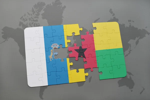 Puzzle con la bandiera nazionale delle isole canarie e ghinea bissau su sfondo mappa del mondo . — Foto Stock