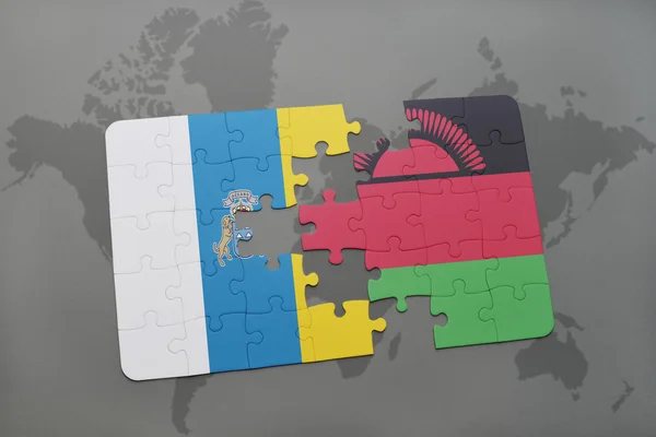 Puzzel met de nationale vlag van de Canarische eilanden en malawi op een wereld kaart achtergrond. — Stockfoto