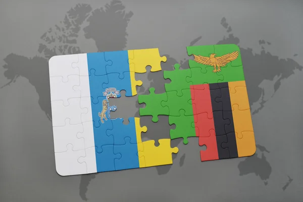 Puzzel met de nationale vlag van de Canarische eilanden en zambia op de achtergrond van een wereld kaart. — Stockfoto