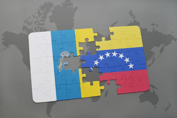 Puzzle with the national flag of canary islands and venezuela on a world map background. — Stock Photo, Image