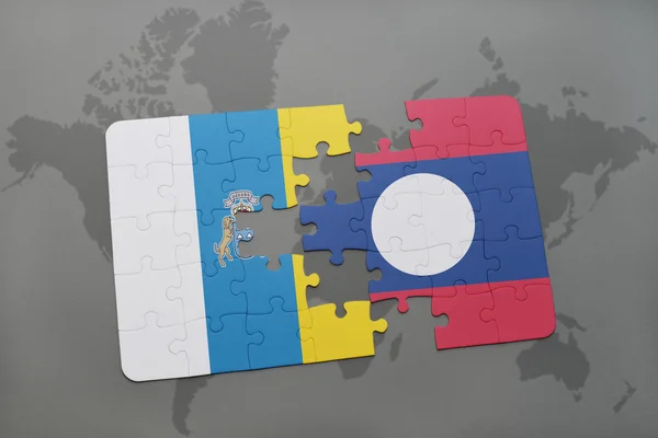 Puzzle con la bandiera nazionale delle isole canarie e laos su uno sfondo mappa del mondo . — Foto Stock