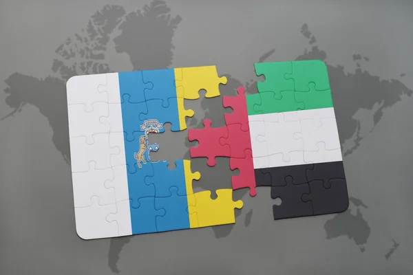 Puzzle avec le drapeau national des îles Canaries et émirats arabes unis sur un fond de carte du monde . — Photo