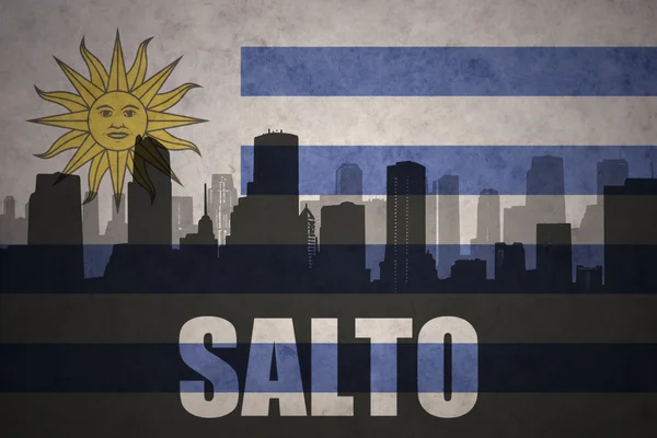 Silhouette astratta della città con testo Salto alla bandiera uruguaiana vintage — Foto Stock
