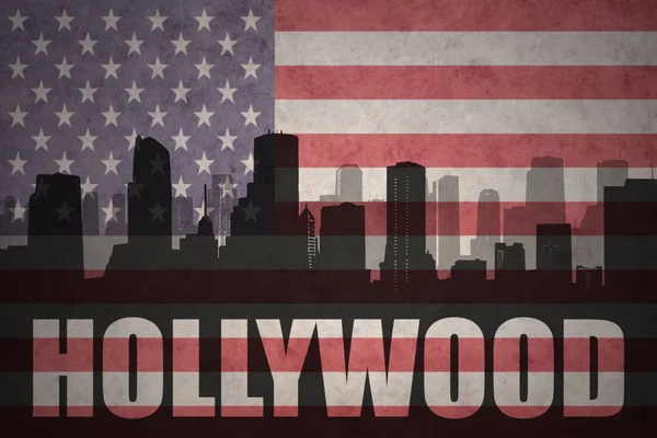 Abstract silhouette of the city with text Hollywood at the vintage american flag — Stock Photo, Image