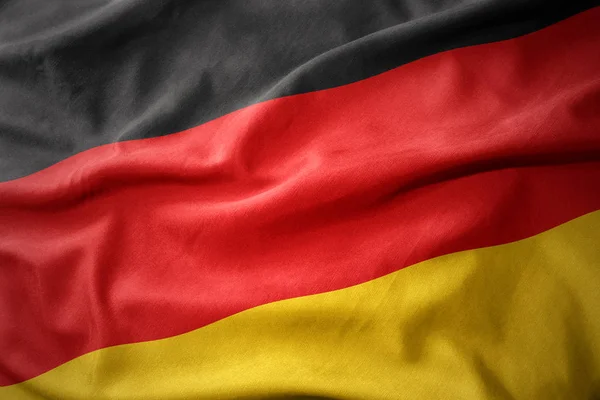 Mává barevná vlajka Německa. — Stock fotografie