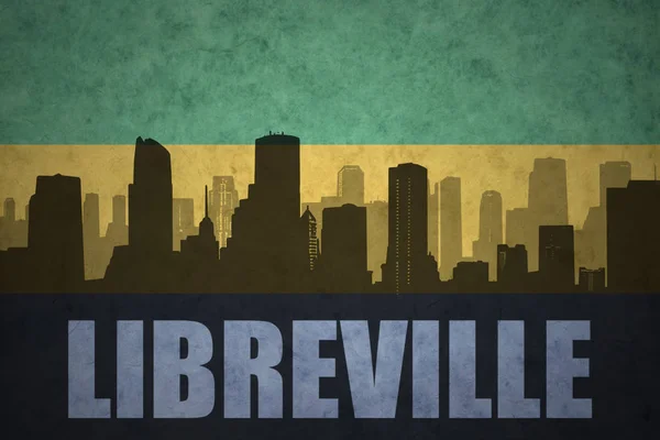 Abstrakta silhuetten av staden med text Libreville på vintage Gabons flagga — Stockfoto