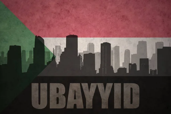 Abstrakte Silhouette der Stadt mit Text ubayyid an der alten sudanesischen Flagge — Stockfoto