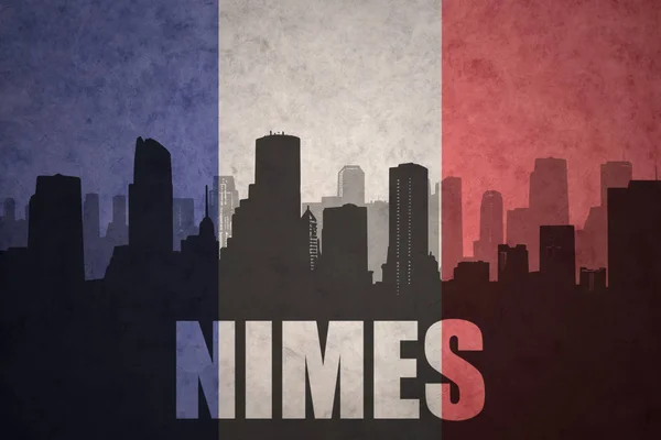 Silhueta abstrata da cidade com texto Nimes na bandeira francesa vintage — Fotografia de Stock