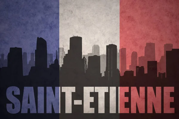 Silhueta abstrata da cidade com texto Saint-Etienne na bandeira francesa vintage — Fotografia de Stock