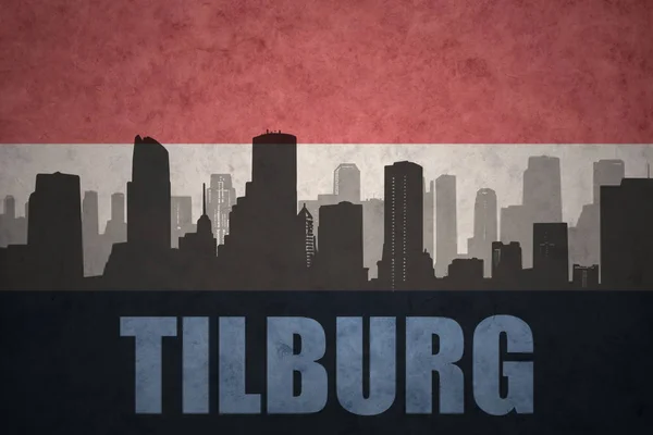 Silhouette astratta della città con testo Tilburg alla bandiera vintage olandese — Foto Stock