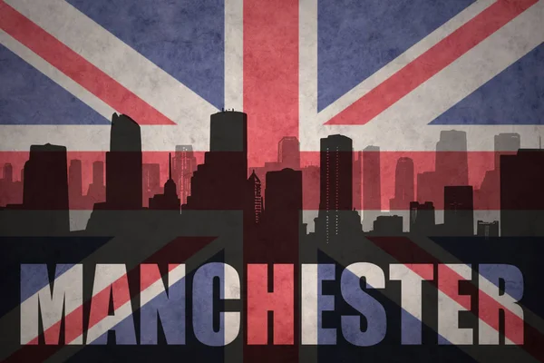 Abstraktní silueta města s textem Manchester na vintage britská vlajka — Stock fotografie