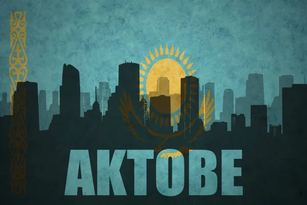 Абстрактный силуэт города с текстом Актобе под винтажным казахстанским флагом — стоковое фото