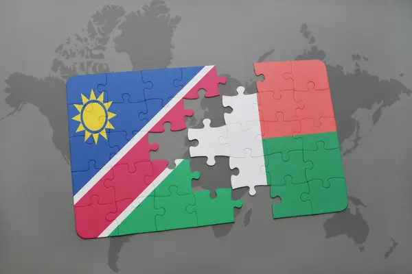 Quebra-cabeça com a bandeira nacional da Namíbia e Madagáscar em um mapa mundial — Fotografia de Stock