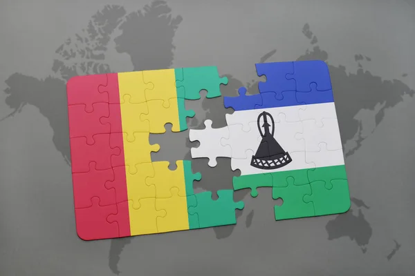 Bir dünya haritası üzerinde Gine ve Lesoto bayrağı ulusal ile bulmaca — Stok fotoğraf