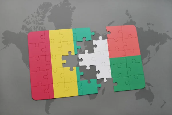 益智与几内亚和马达加斯加的国旗在世界地图上 — 图库照片