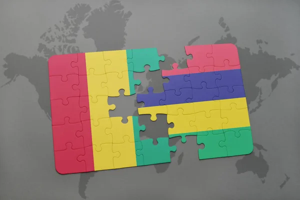 Puzzle mit der Nationalflagge von Guinea und Mauritius auf einer Weltkarte — Stockfoto