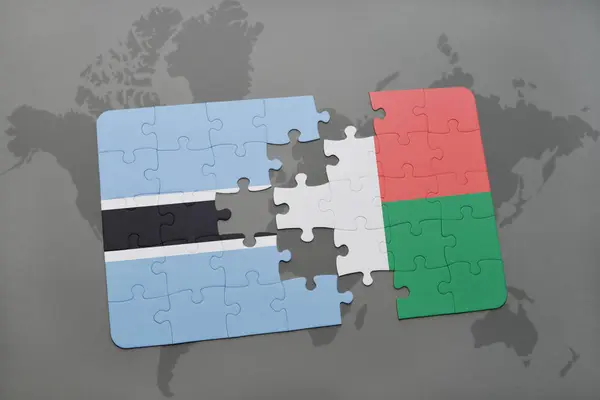Enigma con la bandiera nazionale del Botswana e madagvania su una mappa del mondo — Foto Stock