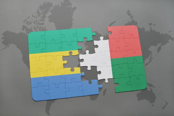 Puzzle avec le drapeau national du Gabon et de Madagascar sur une carte du monde — Photo