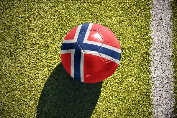 Piłki nożnej z flaga Narodowa Norwegii leży na polu — Zdjęcie stockowe