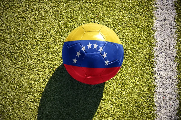 Fotboll boll med flagga venezuela ligger på fältet — Stockfoto