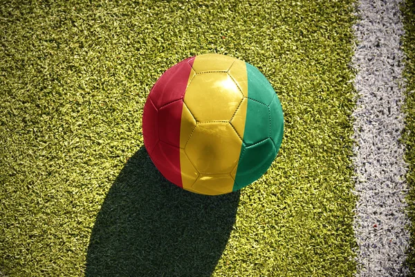 Pelota de fútbol con la bandera nacional de Guinea yace en el campo —  Fotos de Stock