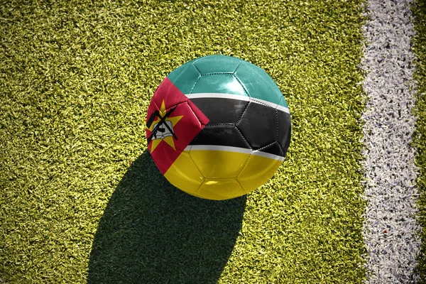 Pelota de fútbol con la bandera nacional de Mozambique en el campo —  Fotos de Stock