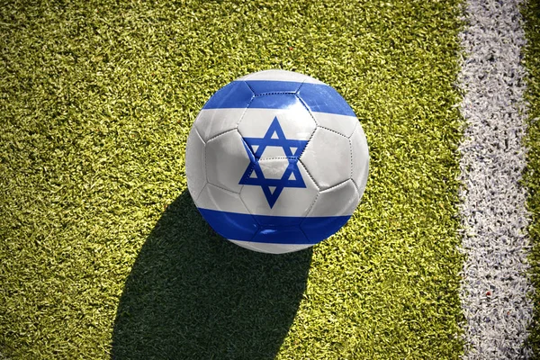 Pelota de fútbol con la bandera nacional de Israel yace en el campo —  Fotos de Stock